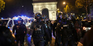 Polizisten patrouillieren vor dem Arc de Triomphe auf der Champs Elysees