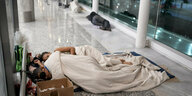 Obdachlose nächtigen im April im Flughafenterminal von Buenos Aires auf dem Boden: Im Vordergrund zwei Personen uner Decken,