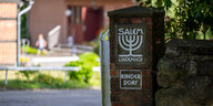 Eine Eingangspforte zu einem Hof. "Salem Lindenhof Kinderdorf" steht auf einem Steinpfosten