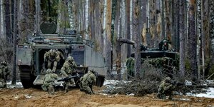 Soldaten kletttern im Wald aus Armeefahrzeugen