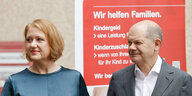 Olaf Scholz und Lisa Paus stehen bei ihrem Besuch bei der Familienkasse Berlin-Brandenburg vor einem Plakat mit der Aufschrift «Wir helfen Familien».
