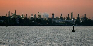 Industrieanlage im roten Abendhimmel am Wasser