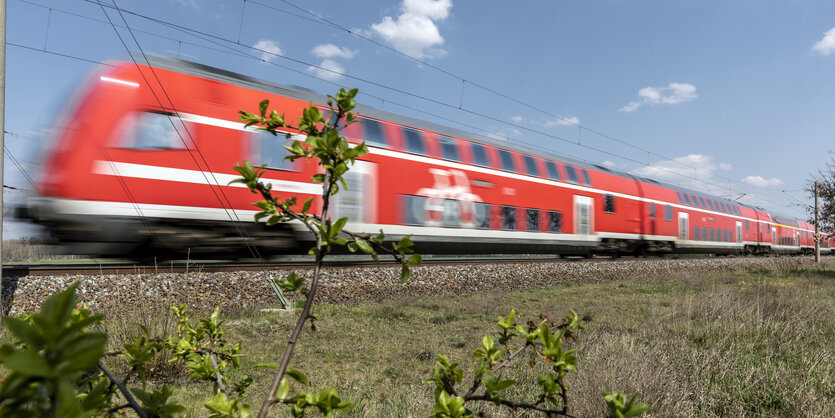 Ein roter Regionalexpress der Deutschen Bahn unterwegs in grüner Landschaft