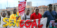 Senegalesen protestieren mit einem großen Banner gegen den Präsidenten Macky Sall