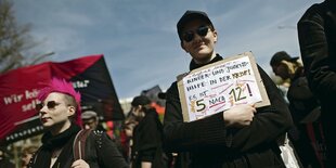 Zwei Demonstrant:innen von unten Fotografiert.