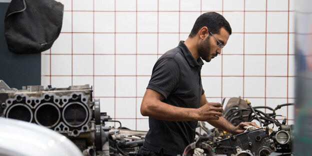 Der 34-jährigen Shenouda Ghaly, Mechatronik-Auszubildender im 2. Lehrjahr, bei Lundtauto Sportwagen-Service, arbeitet am Austausch-Motor eines Porsche.