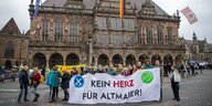 Aktivist*innen stehen vor dem Bremer Rathaus und halten ein Plakat mit der Aufschrift "Kein Herz für Altmaier!"