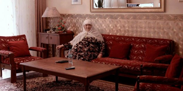 Eine alte Dame auf dem Sofa in ihrem Wohnzimmer