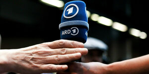 Ein Mikrofon mit ARD-Logo wird weitergereicht, es sind nur di Hände zu sehen