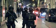 Drei Polizisten stehen nachts auf der Straße nach Marseille