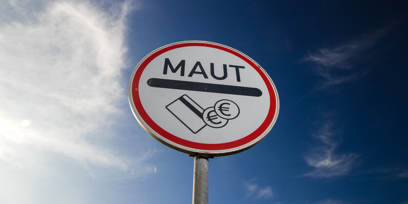 Ein Verkehrsschild mit der Aufschrift "Maut" und Geldsymbolen