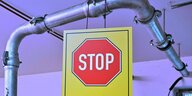 Ein Stopschild hängt an einem Heizungsrohr