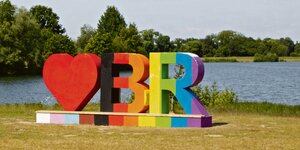 Eine Skulptur, die aus einem Herz und den Buchstaben B und R besteht und in Regenbogenfarben angemalt ist.