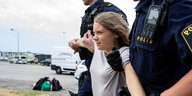 Greta Thunberg wird von zwei Polizisten weggezerrt