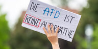Eine Hand hält bei einer Kundgebung gegen eine AfD-Veranstaltung ein Schild mit der Aufschrift „Die AFD ist keine Alternative“ in die Höhe
