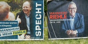 Wahlplakate der beiden Bürgermeisterkandidaten Specht (CDU) und Riehle (SPD) stehen auf einer Wiese