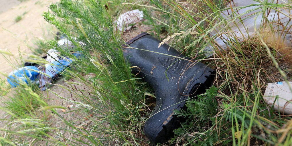 Ein Gummistiefel im Gras an der Oder