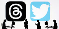 Illustration: Meta Threads and Twitter app logos vor denen schwarze Figuren mit Smartphone stehen, gehen oder am Computer arbeiten