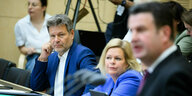Robert Habeck und Nancy Faser hören im Bundestag der Rede von Hubertus Heil zu