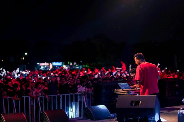 Musiker El Waili rot angeleuchtet mit Blick aufs Publikum in der Nacht