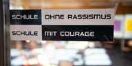 Auf einer Glastür klebt ein Schild mit der Aufschrift "Schule ohne Rassismus - Schule mit Courage"
