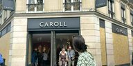 Der Eingangsbereich eines Modegeschäftes in Paris, aus dem Kunden kommen