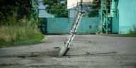 Eine abgefeuerte Bombe mit Streumunition steckt im Asphalt einer Straße in Slaviansk