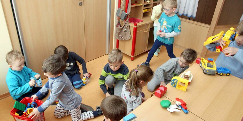 Viele Kinder spielen in einer Kita auf engem Raum