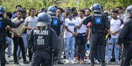 Eine Gruppe von Gegendemonstranten des Eritrea-Festivals steht auf der Straße und wird von Polizisten aufgehalten