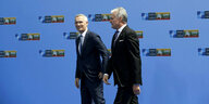 Nato Generalsekretär Jens Stoltenberg und der litauische Präsident Gitanas Nauseda gehen gemeinsam vor einer blauen Wand mit den Logos des Nato-Gipfels