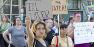 Eine Demonstrantin hält ein schild über ihren Kopf in die Kamera, darauf steht: "Till Täter"