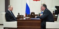 Putin und Posdnjakow im Gespräch, zwischen ihnen ein Tisch