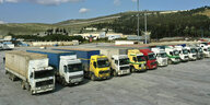 Eine Reihe Lastwagen parkt auf einer großen Freifläche