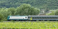 Brennerbahn der italienischen Bahn bei Ala. Die Trasse führt durch das sommerlicheTal der Etsch zwischen Weinreben und begrünten Berghängen