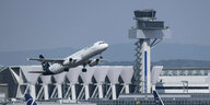 Eine Passagiermaschine der Lufthansa startet am Flughafen Frankfurt am Main, im Hintergrund ist ein Terminal zu sehen