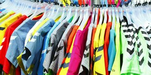 Bunte T-Shirts auf Kleiderbügeln hängend