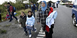 Eine Flüchtlingsfamilie läuft auf einer Straße