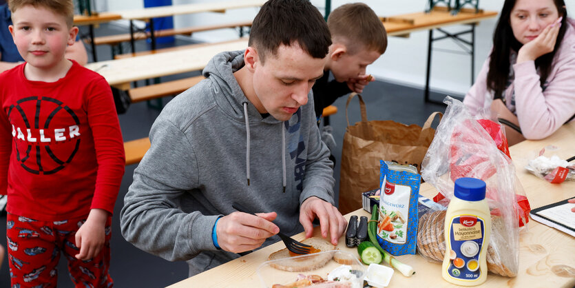 Eltern bereiten einen Snack für ihre Kinder vor im Ankunftszentrum Ukraine in Tegel