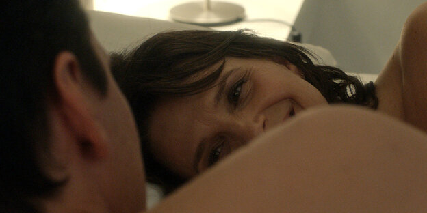 In einer zärtlichen Bettszene des Films lächelt Sara, gespielt von Juliette Binoche ihrem Bettpartner zu