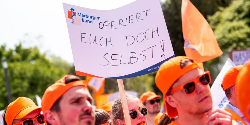 Warnstreik mit einem Plakat "Operiert euch doch selbst"