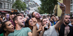 Feiernde Menschen machen ein Sefie mit ihrem Smartphone