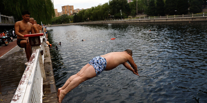 Eine Person springt in einen Fluss.