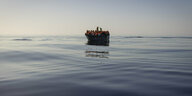 Ein Boot mit Geflüchteten auf dem Mittelmeer, die Rettungswesten des Rettungsschiffs Ocean Viking tragen