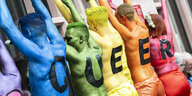 In verschiendenen Farben angemalte Teilnehmer des CSD haben auf dem Rücken jeweils einen Buchstaben, der das Wort QUEER ergibt