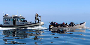 Schiff der tunesischen Küstenwache neben einem Migrantenboot.
