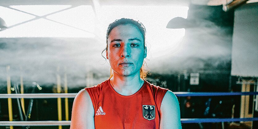 Die Boxerin Sarah Scheurich steht in einem Raum mit Trainingsgeräten.