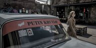 Straßenszene in Tiflis. Auf einem Auto steht auf Georgisch "Putin ist ein Dummkopf"