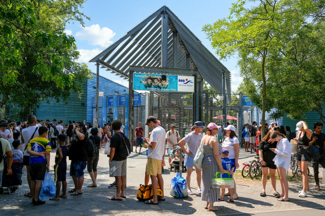 Schlange vor dem Columbiabad. Viele Menschen warten auf's Freibad.