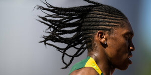 Caster Semenya im Profil läuft und die Haare fliegen in der Luft