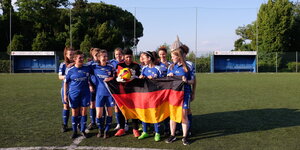 Das Pichanga-Fußballteam mit deutscher Fahne auf dem Rasen